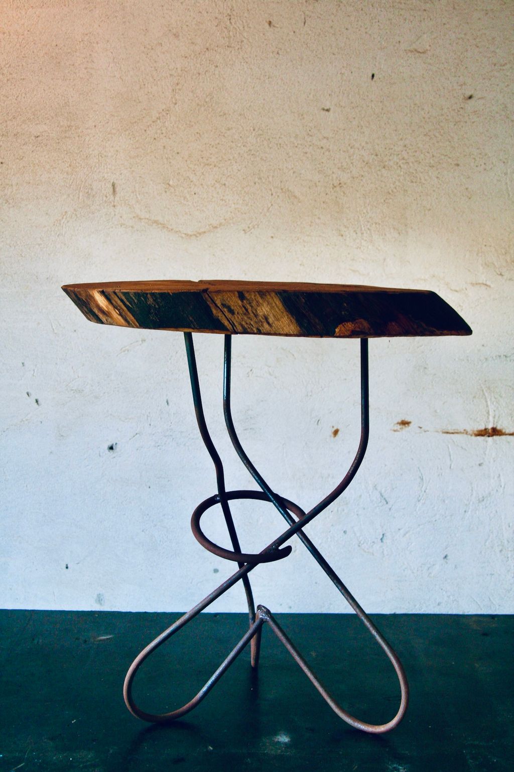 Træbord med snoede jernben op imod en hvid væg