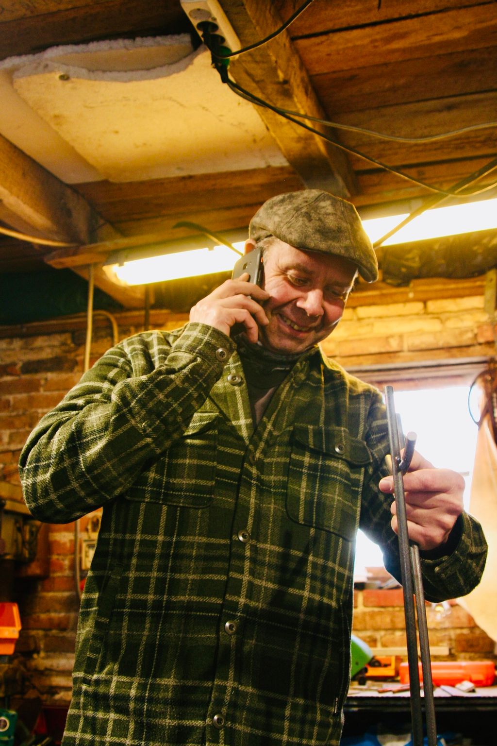 En glad og imødekomende Finn i smedjen med en telefon